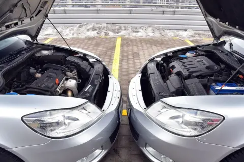 Dwa silniki samochodowe, jeden diesel, drugi benzyna, stoją obok siebie.
