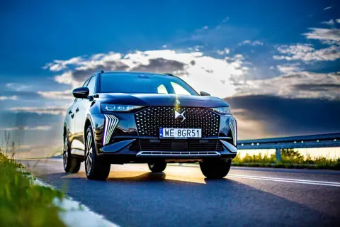 Czarny DS7 Crossback na tle dramatycznego nieba. Elegancki SUV z charakterystycznym grillem i światłami LED.