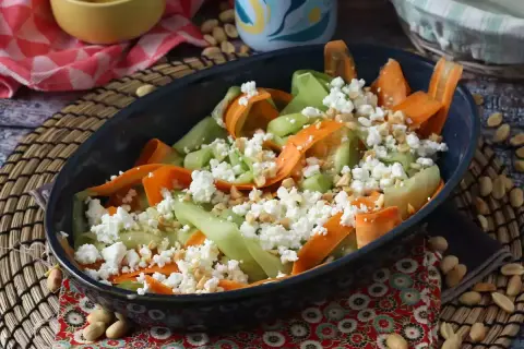 En härlig somrig sallad med strimlad morot och gurka, toppad med smulad fetaost och hackade nötter. Perfekt för en lätt lunch.