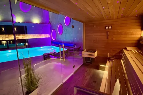 Relaks w spa w Rudzie Śląskiej: basen z niebieską wodą i nowoczesna sauna z drewnianymi ławami.