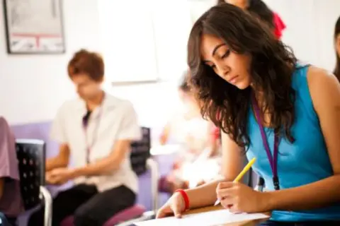 Jóvenes concentrados en un examen, quizás el ejemplo examen habilitación lingüística Madrid.