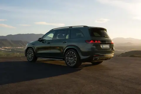 Mercedes más potente, un SUV oscuro aparcado en una colina con vistas a un valle al atardecer.