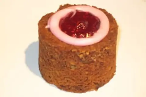 En cylinderformad Runebergstårta med rosa glasyr och hallonsylt i mitten. Perfekt för dig som söker ett runebergstårta recept.