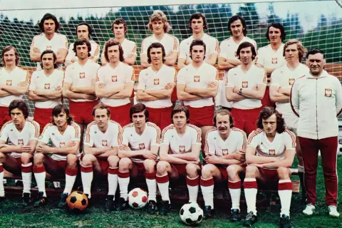 Reprezentacja Polski 1974 skład: piłkarze w białych koszulkach z orłem i czerwonych spodenkach pozują do zdjęcia przed bramką.