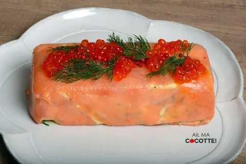 Une délicieuse terrine de saumon, garnie de perles rouges et d'aneth frais, prête à être dégustée.