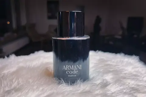 Elegancki flakon Armani Code Parfum na puszystym białym tle.