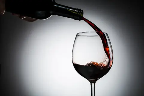 Czerwone wino nalewane do kieliszka. Czy czerwone wino jest zdrowe? Dyskusja trwa, ale jego piękny kolor zachwyca.