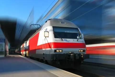 Pędzący pociąg z czerwonymi pasami. Pamiętaj o swoim odszkodowanie za opóźnienie pociągu, jeśli podróż się przedłuży.