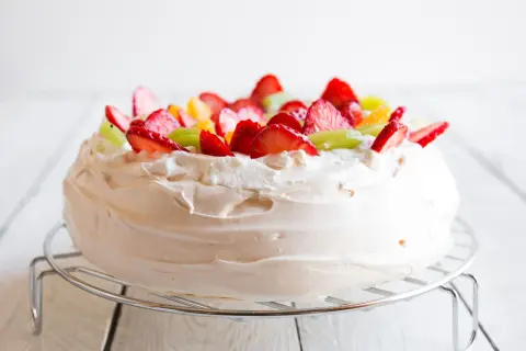 Puszysta masa do pavlovej ozdobiona truskawkami, kiwi i pomarańczą.