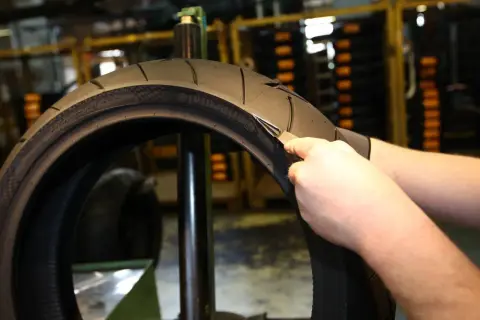 Inspección de un neumático de moto para determinar cada cuanto cambiar neumaticos moto. Se revisa el desgaste y la profundidad del dibujo.