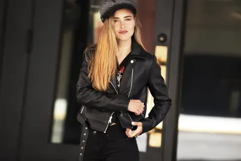 Dziewczyna w czarnej ramonesce i czapce, uosobienie rockowego stylu ubierania.