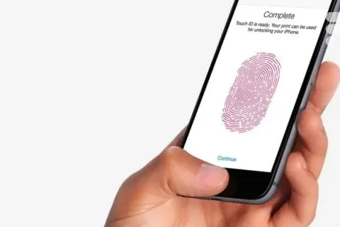 Main d'une personne tenant un iPhone 13, configurant le Touch ID pour déverrouiller son appareil.