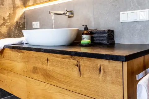 Modernes Badezimmer mit Waschtischunterschrank aus massivem Holz. Die Schubladenfronten zeigen die natürliche Maserung des Holzes, eine tolle Idee für Ihr Bad.