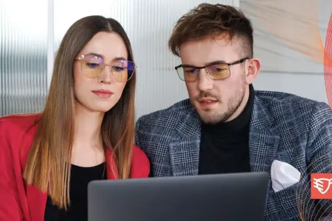 Para dyskutuje o tym, czy okulary ochronne psują wzrok, patrząc na laptopa.