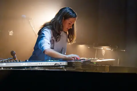 Artystka tworzy muzykę, jakby grała piosenkę z filmu Absolwent, z pasją naciskając klawisze syntezatora.