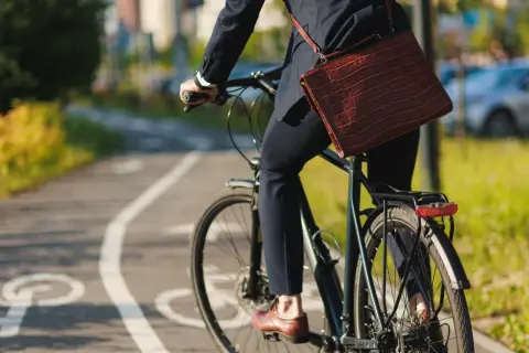 Biznesmen na rowerze, jadący ścieżką rowerową. Czy za jazdę na rowerze zabierają prawo jazdy? Raczej nie, chyba że łamie się przepisy.