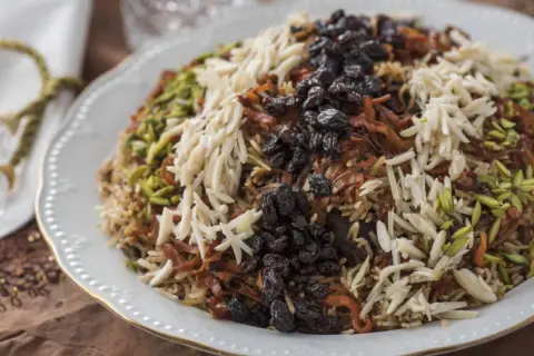 En generös portion kabuli pulao, toppad med russin, mandelflagor och pistagenötter.