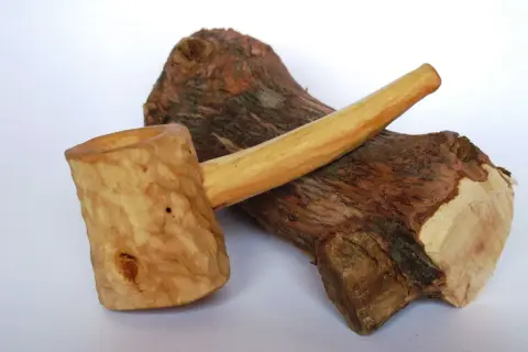 Cazoleta de brezo madera, tallada a mano, con un tronco rústico de fondo.