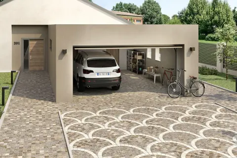 Un'auto bianca è parcheggiata in un garage aperto. Il vialetto carrabile del giardino è pavimentato con piastrelle decorative a ventaglio.