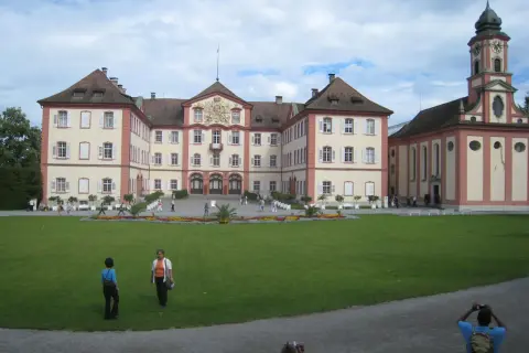 Mainau slott med sitt imponerande torn och vackra trädgårdar. En solig dag med moln på himlen.