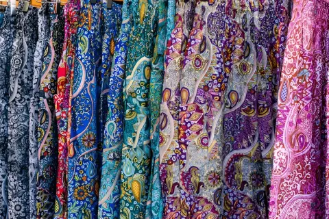 Bunte Stoffe mit Paisley-Muster, wie sie für Popeline typisch sind, hängen nebeneinander.