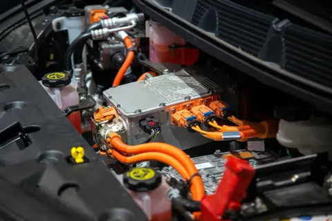 Componentes de un coche eléctrico, listos para cambiar la centralita. Cables naranjas y conectores naranjas y negros.