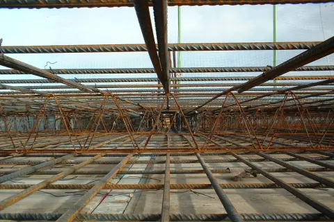 Siatka zbrojeniowa i stalowe pręty tworzą skomplikowaną konstrukcję, gotową do zalania betonem. To półfabrykat hutniczy, który wzmocni przyszły budynek.