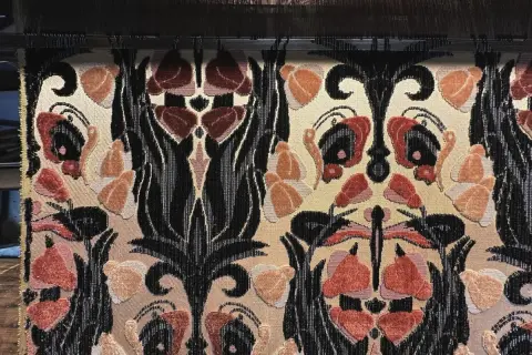 Tessitura Bevilacqua Venezia: un tessuto prezioso con motivi floreali e volute nere su fondo beige, che evoca l'eleganza veneziana.