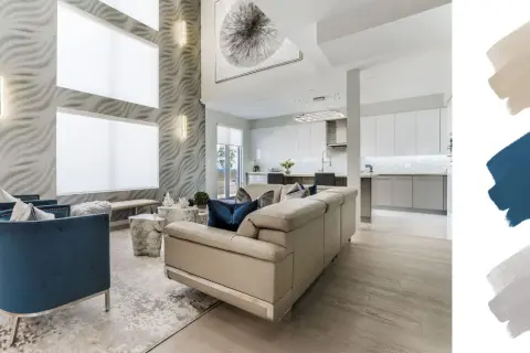 A modern living room with a textured wall, blue velvet chairs, and a cream sofa. The interior design color schemes feature beige, navy, and grey swatches.