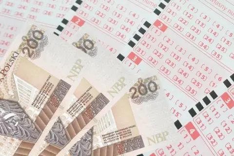 Banknoty 200 zł leżą na kuponach lotto. Dowiedz się, jak sprawdzić datę ważności zdrapki i co zrobić, gdy termin minął.