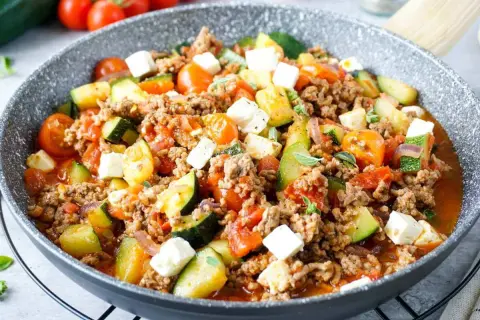 Herzhafte zucchinipfanne mit Hackfleisch, Tomaten und Feta. Ein schnelles und leckeres Gericht aus der Pfanne.