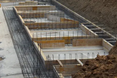 Szkielet zbrojeniowy i szalunki drewniane czekają na beton. Tak wygląda budowa fundamentów krok po kroku.