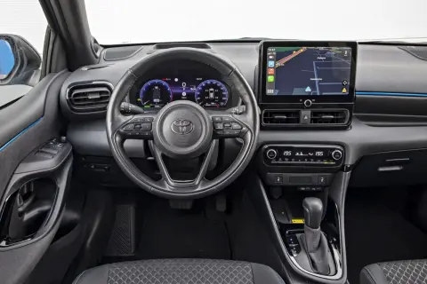 Wnętrze Toyoty Yaris Hybrid. Nowoczesny kokpit z ekranem nawigacji i cyfrowymi zegarami. Sprawdź atrakcyjną toyota yaris hybrid cena.