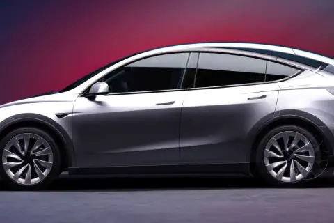 Srebrny Tesla SUV z opływowymi liniami i futurystycznym designem, prezentowany na tle gradientowego tła.