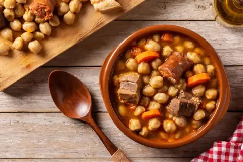 Un delicioso plato de garbanzos con chorizo y carne, perfecto para comer cocido en Zaragoza.