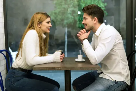 Para rozmawia przy stoliku w kawiarni. On słucha uważnie, ona opowiada, jak rozmawiać z dziewczyną.
