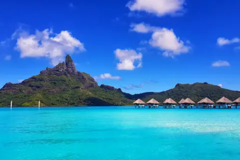 Bora Bora: idealna pogoda, turkusowa woda, góry i domki na wodzie.