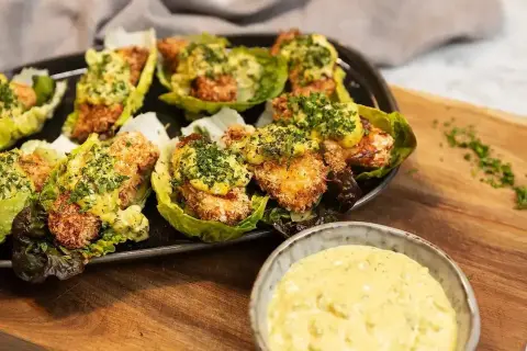 Krispiga bitar i salladsblad toppade med en krämig sås. Perfekt tillbehör till ditt remouladsås recept.