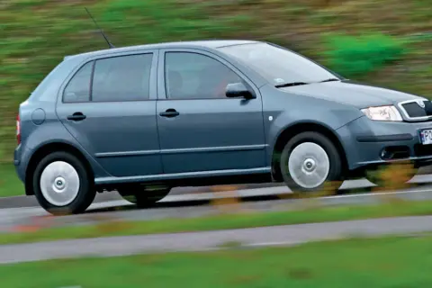 Szara Skoda Fabia 1 w ruchu, z rozmytym tłem zieleni i drogi.