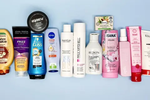 Eine Auswahl an Haarspülungen, darunter Produkte von Garnier, John Frieda und Nivea, einige mit Inhaltsstoffen wie Stearamidopropyl Dimethylamine für glänzendes Haar.
