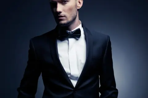 Ein Mann im eleganten Anzug mit Fliege. Der Smoking-Stil unterstreicht seine maskuline Ausstrahlung.