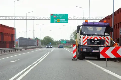 Ciężarówka drogowa z pachołkami ostrzegawczymi. Kierowca może otrzymać mandat za wyprzedzanie na podwójnej ciągłej.