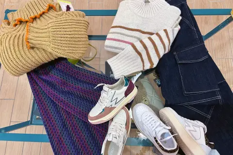 Sneakers: cosa sono? Scarpe comode e alla moda, perfette per ogni outfit. Ecco un esempio di look casual con maglioni, jeans e una borsa.