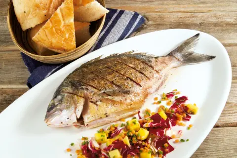 Gegrillte Dorade mit einem bunten Salat aus Radicchio, Linsen und Mango. Ein leichter Salat, der wunderbar zeigt, welcher Salat passt zu Dorade. Dazu gibt es frisches Brot.