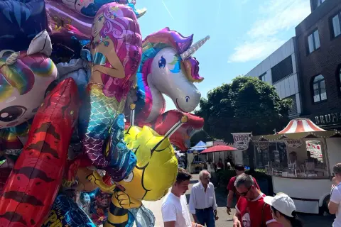 Bunte Ballons mit Einhorn und Meerjungfrau beim Stadtfest Bensberg. Menschen schlendern an Ständen vorbei.