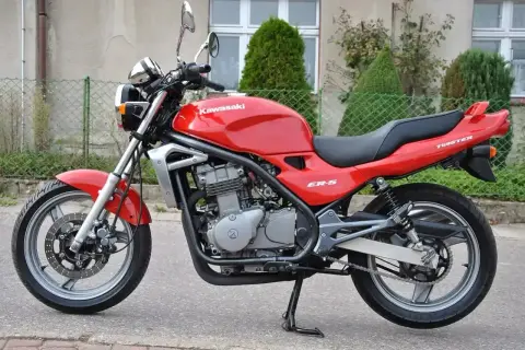 Czerwony Kawasaki ER-5, gotowy do jazdy po miejskich ulicach.
