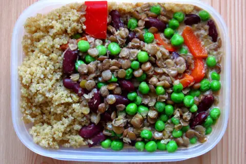 En näringsrik vegetarisk matlåda med quinoa, linser, bönor, ärtor och paprika. Perfekt för en hälsosam lunch!