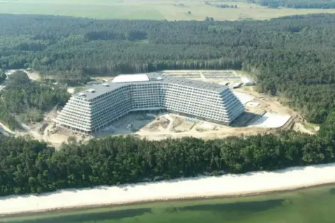 Hotel Gołębiewski Pobierowo kiedy otwarcie? Ogromny hotel w budowie na tle lasu i plaży.