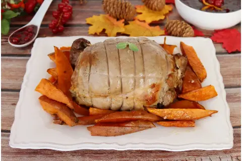 Un succulento arrosto di tacchino, cotto alla perfezione, servito su un letto di patate dolci arrostite. Un piatto autunnale invitante.