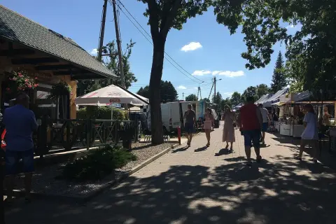 Tleń atrakcje: ludzie spacerują po rynku, podziwiając stoiska z rękodziełem i lokalnymi produktami.